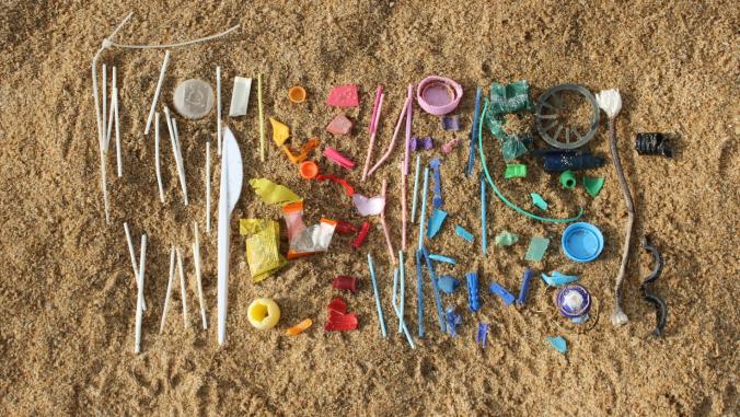A rainbow of plastic waste on a beach.