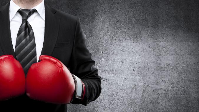 Business person wearing boxing gloves