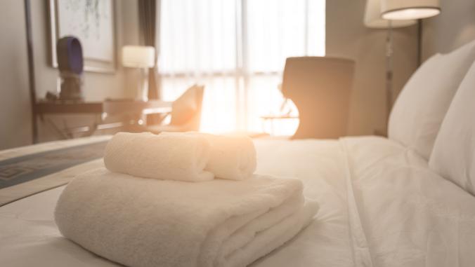 A hotel room with towels on the bed