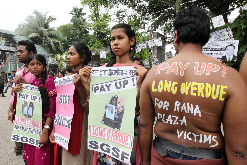 Demonstrators hold signs about Rana Plaza collapse 