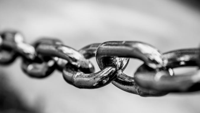 Several links in a metal chain depicted in black and white