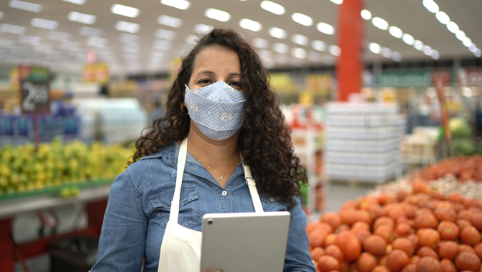 Worker in a grocery store, wearing a mask